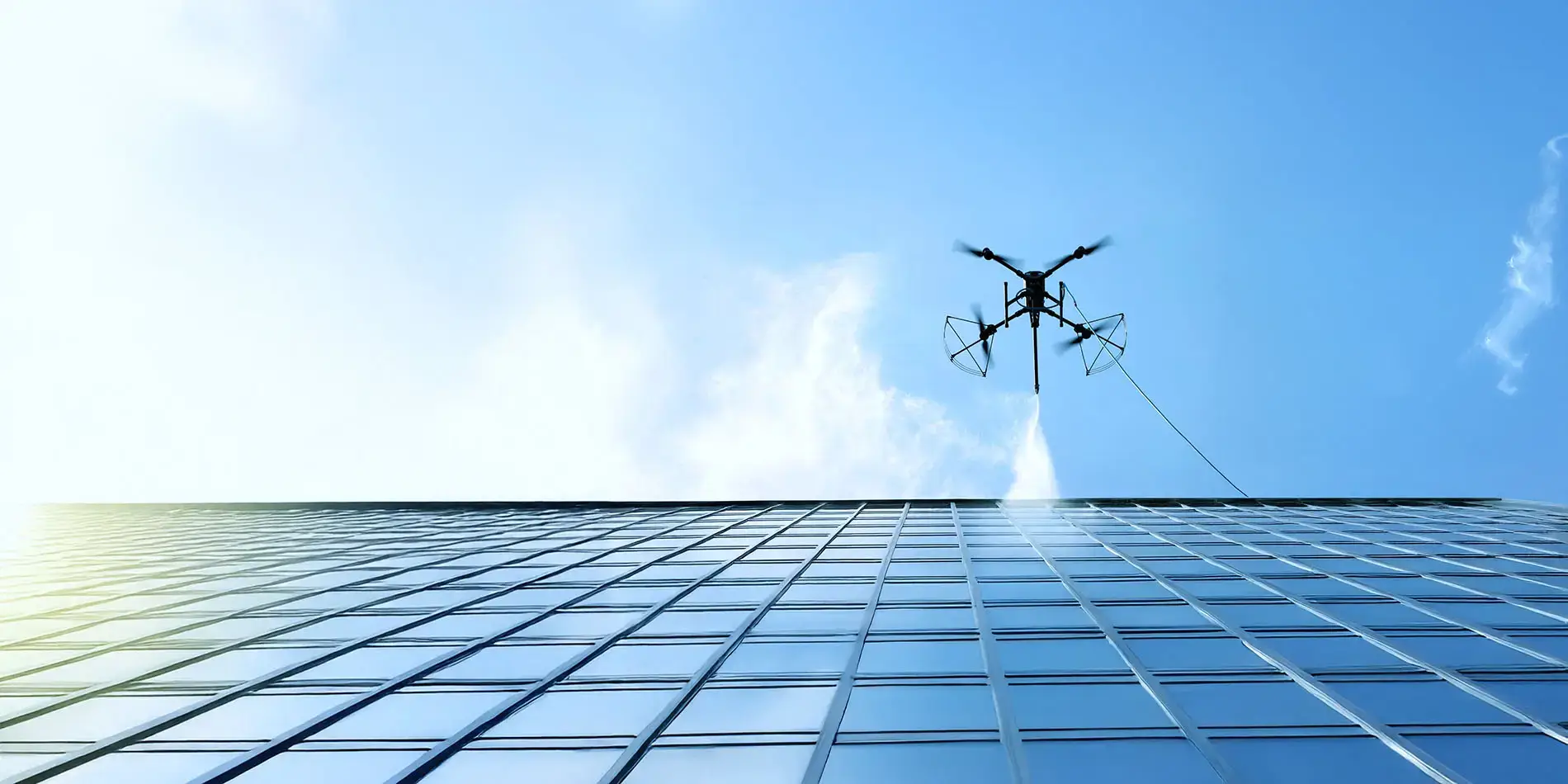 Commercial building exterior maintained by drone-based cleaning program